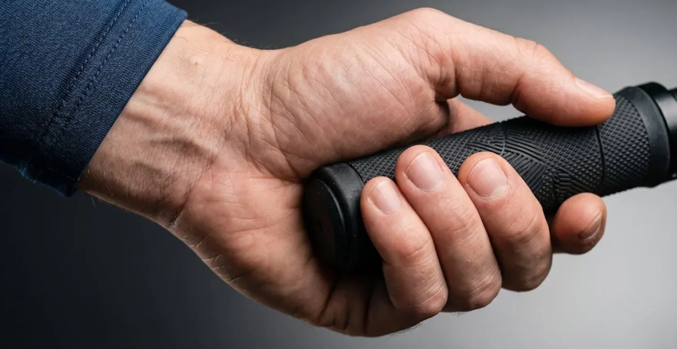 Detailaufnahme einer Hand am Fahrradlenker mit anatomischem Fokus auf Handballenbereich und Druckzonen