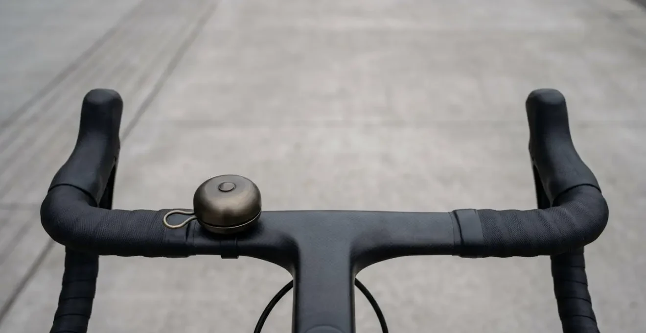 Minimalistisches Fahrradklingel-Design am Carbonlenker eines Rennrads montiert