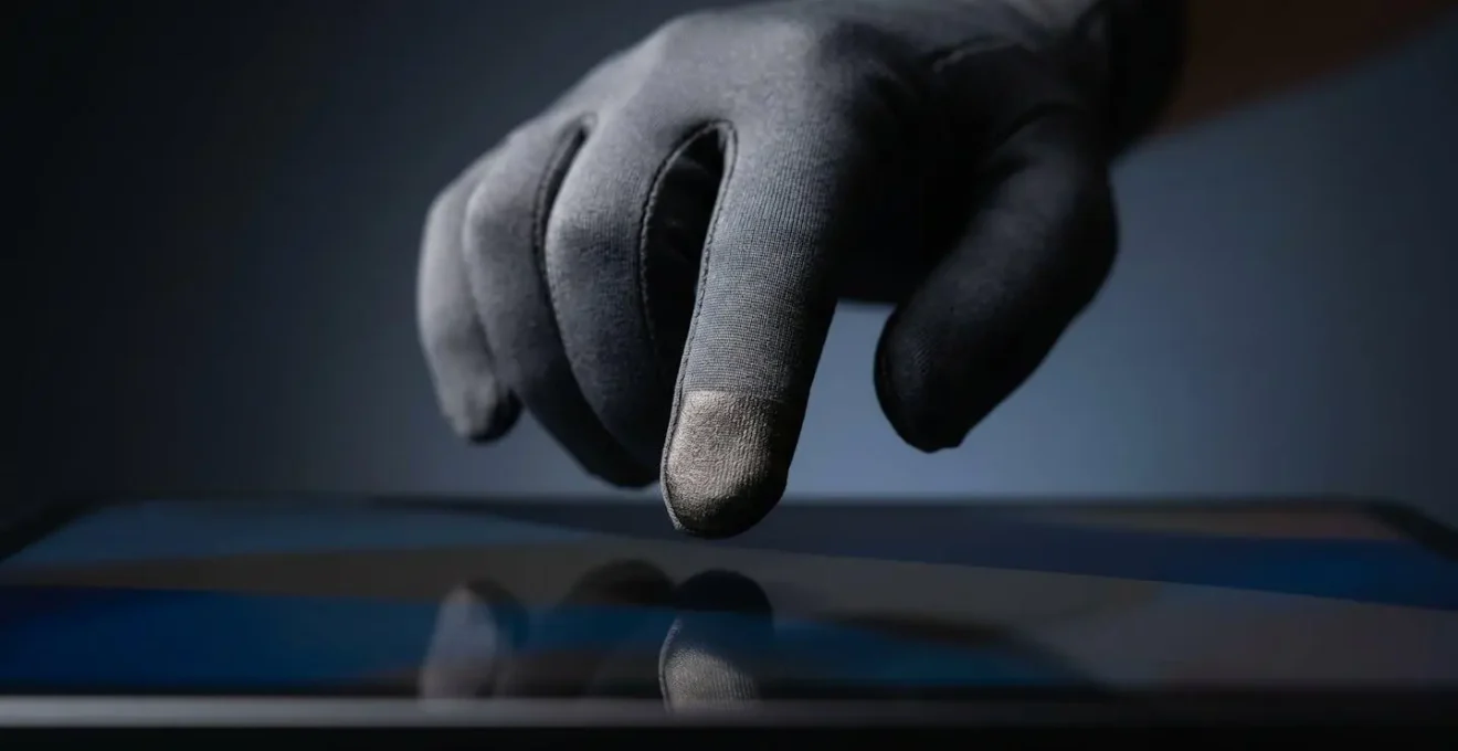 Nahaufnahme der Fingerspitze eines Touchscreen-Handschuhs mit sichtbarer leitfähiger Faserstruktur unter natürlichem Licht