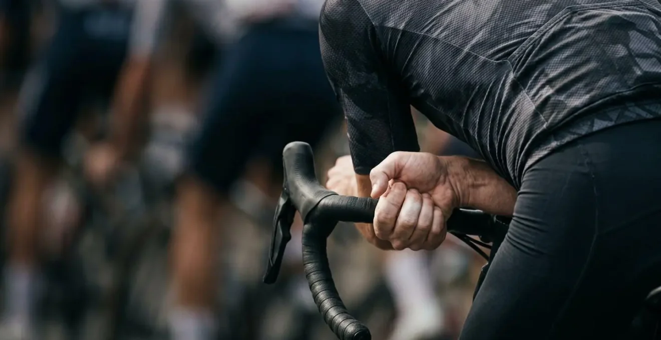 Detailaufnahme der aerodynamischen Positionierung eines Radsportlers im Windschatten kurz vor dem Sprint-Antritt